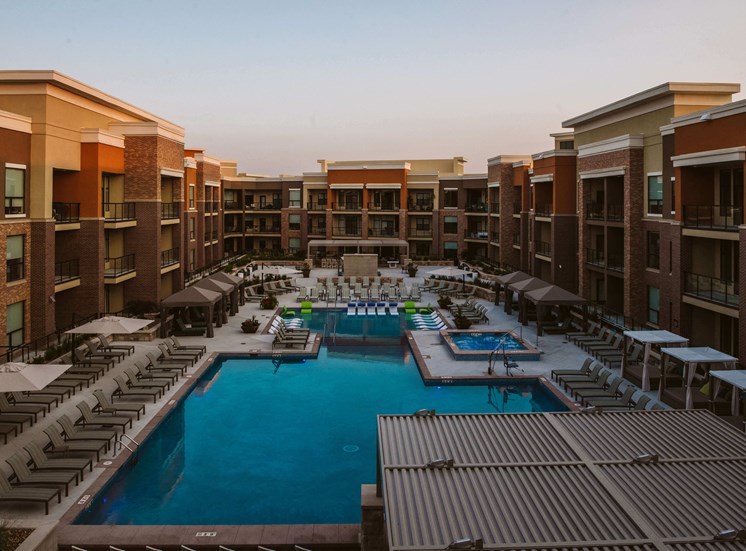 aerial view of apartment complex with a pool and outdoor seating in the center